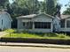 Charming, light blue one-story home featuring a screened-in porch and a small, overgrown front yard at 501 Holly Nw St, Atlanta, GA 30318