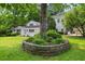 Scenic backyard with a stone-lined garden bed, lush green lawn, and mature trees at 6771 Sunny Brook Ln, Atlanta, GA 30328
