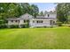 Expansive backyard featuring lush lawn, mature trees, and a charming back deck for outdoor living at 6771 Sunny Brook Ln, Atlanta, GA 30328