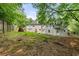Large backyard with mature trees, firepit and a two story house with a patio at 6771 Sunny Brook Ln, Atlanta, GA 30328
