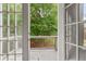 Balcony view through glass doors with wood railing overlooking lush greenery at 6771 Sunny Brook Ln, Atlanta, GA 30328