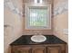 Powder room with decorative window, black countertop, and stylish fixtures at 6771 Sunny Brook Ln, Atlanta, GA 30328