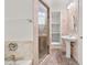 Bathroom with shower, pedestal sink, tile floors, and a shelving unit at 6771 Sunny Brook Ln, Atlanta, GA 30328