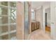 Well-lit bathroom with glass shower, tiled walls, vanity, and a separate door to a closet at 6771 Sunny Brook Ln, Atlanta, GA 30328