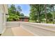 Outdoor deck overlooking a yard with mature trees and a brick house in the distance at 6771 Sunny Brook Ln, Atlanta, GA 30328