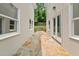Exterior stone pathway between two buildings with white exterior and dark trimmed windows and doors at 6771 Sunny Brook Ln, Atlanta, GA 30328