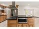 Stainless hood vent hovers above a large kitchen island with gas cooktop, microwave, and granite counters at 6771 Sunny Brook Ln, Atlanta, GA 30328