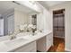 Bathroom features a double sink vanity with white cabinets and a large mirror and access to the closet at 85 Dunwoody Springs Dr, Sandy Springs, GA 30328