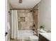 A bathtub and shower combination has decorative tiles and a white shower curtain at 85 Dunwoody Springs Dr, Sandy Springs, GA 30328