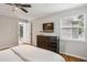 This bedroom has hardwood floors, a window, and a dresser with a television hanging above it at 85 Dunwoody Springs Dr, Sandy Springs, GA 30328