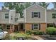 Inviting townhouse with brick facade, black shutters, mature landscaping, and a private entrance at 85 Dunwoody Springs Dr, Sandy Springs, GA 30328