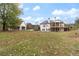 Rear exterior featuring a multi-tiered deck, a spacious lawn, and mature trees at 100 Percheron Dr, Canton, GA 30114
