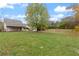 Rear exterior featuring a large lawn, mature trees, and a detached garage at 100 Percheron Dr, Canton, GA 30114