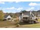 Rear exterior featuring a multi-tiered deck, a spacious lawn, and lush trees at 100 Percheron Dr, Canton, GA 30114