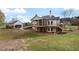 Rear exterior featuring a multi-tiered deck, a spacious lawn, and lush trees at 100 Percheron Dr, Canton, GA 30114