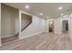 Spacious basement area with stairs, neutral walls, wood floors, and access to a bathroom and hallway at 100 Percheron Dr, Canton, GA 30114