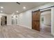Bright, open basement featuring wood-look flooring and a modern sliding barn door at 100 Percheron Dr, Canton, GA 30114