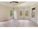 Light-filled bedroom with tray ceiling, wood-look flooring, and windows overlooking deck at 100 Percheron Dr, Canton, GA 30114