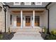 Inviting entrance featuring triple wood doors, white columns, and brick steps at 100 Percheron Dr, Canton, GA 30114