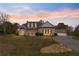 Charming home with a long driveway, illuminated by the soft glow of dusk with colorful sky at 100 Percheron Dr, Canton, GA 30114