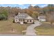 Charming home showcasing a long driveway and a detached garage, set against a backdrop of lush trees at 100 Percheron Dr, Canton, GA 30114
