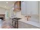 Close up shot of modern kitchen with stainless steel range, stone fireplace, and custom cabinetry at 100 Percheron Dr, Canton, GA 30114