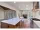 Spacious kitchen featuring a large island, stone fireplace, stainless steel appliances, and custom cabinetry at 100 Percheron Dr, Canton, GA 30114