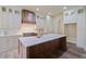 Bright kitchen features a large island, custom range hood, and white cabinets with glass fronts at 100 Percheron Dr, Canton, GA 30114