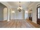 Bright living room with arched doorways, decorative chandelier, and beautiful hardwood flooring at 100 Percheron Dr, Canton, GA 30114