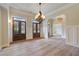 Bright living room featuring double doors, arched doorways, chandelier, and beautiful hardwood flooring at 100 Percheron Dr, Canton, GA 30114