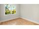 Neutral bedroom featuring hardwood floors, white trim, and a view of mature trees outside the window at 1697 Thomas St, Decatur, GA 30032