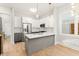 Modern kitchen boasts stainless steel appliances, gray island, and bright white cabinets and subway tile backsplash at 1697 Thomas St, Decatur, GA 30032