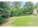 Large backyard with lush green grass and mature trees providing privacy at 1765 Pinetree Pass Lane Southwest Sw Ln, Lilburn, GA 30047