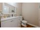 Powder room featuring white vanity, rectangular mirror and wood floor at 1765 Pinetree Pass Lane Southwest Sw Ln, Lilburn, GA 30047