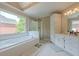 Bright bathroom featuring a soaking tub, large window, and glass-enclosed shower at 1765 Pinetree Pass Lane Southwest Sw Ln, Lilburn, GA 30047