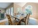Bright dining room featuring a rustic wood table, six chairs, and a large window with views of the wooded backyard at 1765 Pinetree Pass Lane Southwest Sw Ln, Lilburn, GA 30047