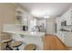 Bright kitchen featuring white cabinets, stainless steel appliances, bar seating and hardwood floors at 1765 Pinetree Pass Lane Southwest Sw Ln, Lilburn, GA 30047