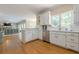 Spacious kitchen with stainless appliances, white cabinets, hardwood floors and an open view to the living room at 1765 Pinetree Pass Lane Southwest Sw Ln, Lilburn, GA 30047