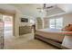 Spacious main bedroom featuring a tray ceiling, ceiling fan, and access to ensuite bathroom with large tub at 1765 Pinetree Pass Lane Southwest Sw Ln, Lilburn, GA 30047