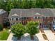 Aerial view of brick townhomes with two-car garages, well-kept lawns, and tree-lined streets at 2264 Ewell Park Dr, Lawrenceville, GA 30043