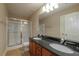 Bathroom featuring a dual sink vanity with granite countertop, a shower and tile floors at 2264 Ewell Park Dr, Lawrenceville, GA 30043