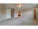 A bedroom with three doors, a ceiling fan, neutral paint, carpet and access to an ensuite bathroom at 2264 Ewell Park Dr, Lawrenceville, GA 30043