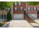 Brick townhome featuring a driveway, two car garage, and traditional architectural details at 2264 Ewell Park Dr, Lawrenceville, GA 30043
