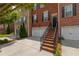 Beautiful two-story brick townhome featuring a spacious two-car garage and a welcoming brick staircase to the front door at 2264 Ewell Park Dr, Lawrenceville, GA 30043