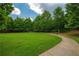 Lush green community park with walking path and benches, surrounded by mature trees at 2264 Ewell Park Dr, Lawrenceville, GA 30043
