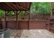 Private patio with stone pavers, privacy fence, covered seating area, and wooded views at 2264 Ewell Park Dr, Lawrenceville, GA 30043