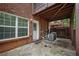 Stone patio with brick wall, covered seating area, and air conditioning condenser at 2264 Ewell Park Dr, Lawrenceville, GA 30043