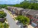 Street view showcasing a row of brick townhomes with well-manicured lawns and mature trees at 2264 Ewell Park Dr, Lawrenceville, GA 30043
