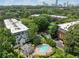Aerial view of the community featuring well-maintained buildings, lush trees, a pool, and cityscape backdrop at 23307 Plantation Ne Dr, Atlanta, GA 30324