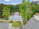 Scenic aerial view of a home overlooking a serene pond, complemented by lush green trees at 795 Lake Medlock Dr, Alpharetta, GA 30022